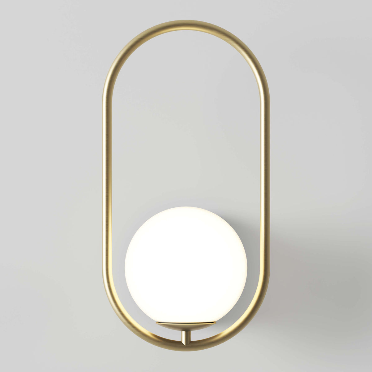 A modern wall sconce featuring a round white globe light set within an elongated oval gold metal frame against a light gray background.