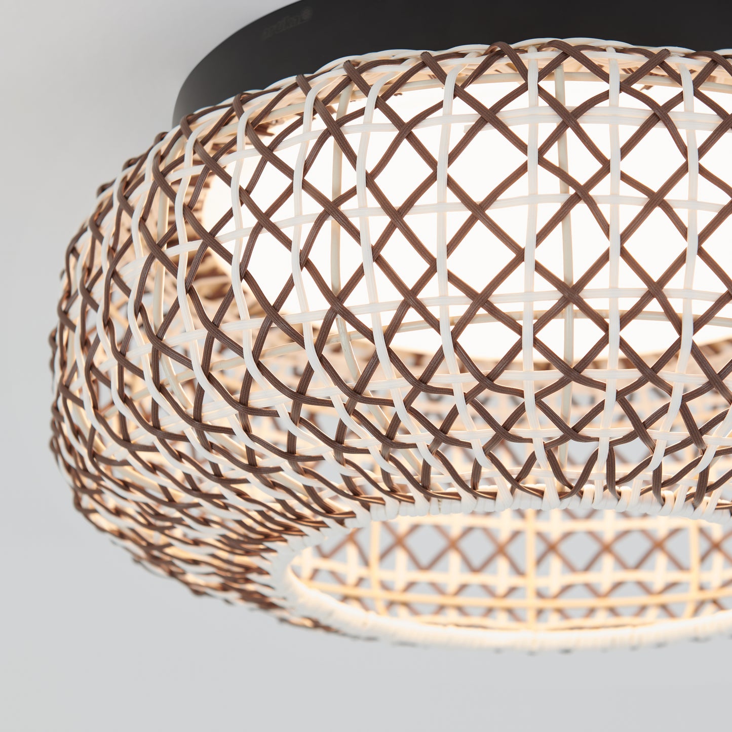 Close-up of the Artika Benson 15 in. LED flush mount light, featuring a brown and white basket-weave design with geometric patterns encircling the circular light source and offering 5 color temperature options.