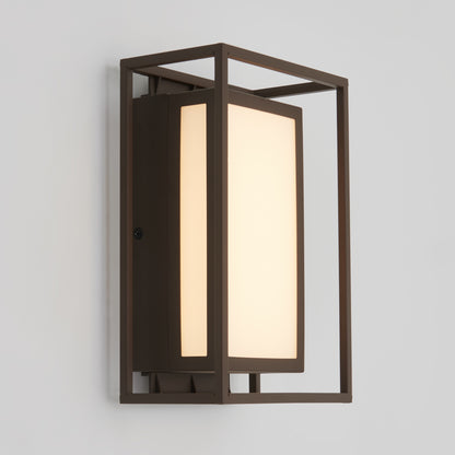 The Artika Ghost indoor-outdoor LED wall light features a modern design with a rectangular frosted glass shade set in a dark metal frame, mounted on a white wall.