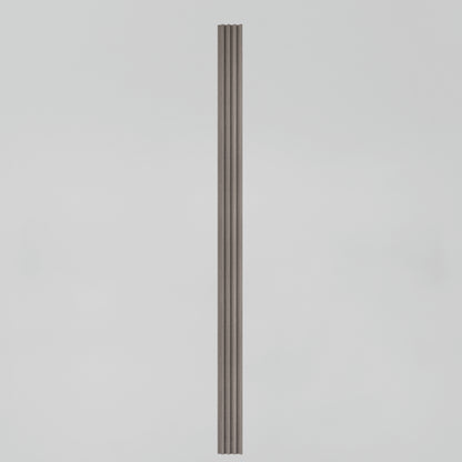 A tall, narrow, vertical object with parallel grooves, resembling a fluted column, stands centered against a plain light gray background.