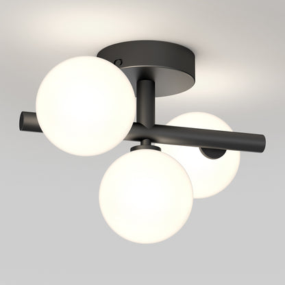 The Artika Bloom LED flush mount features three frosted glass globes on intersecting rods with a matte black base, creating a modern accent against a white ceiling.