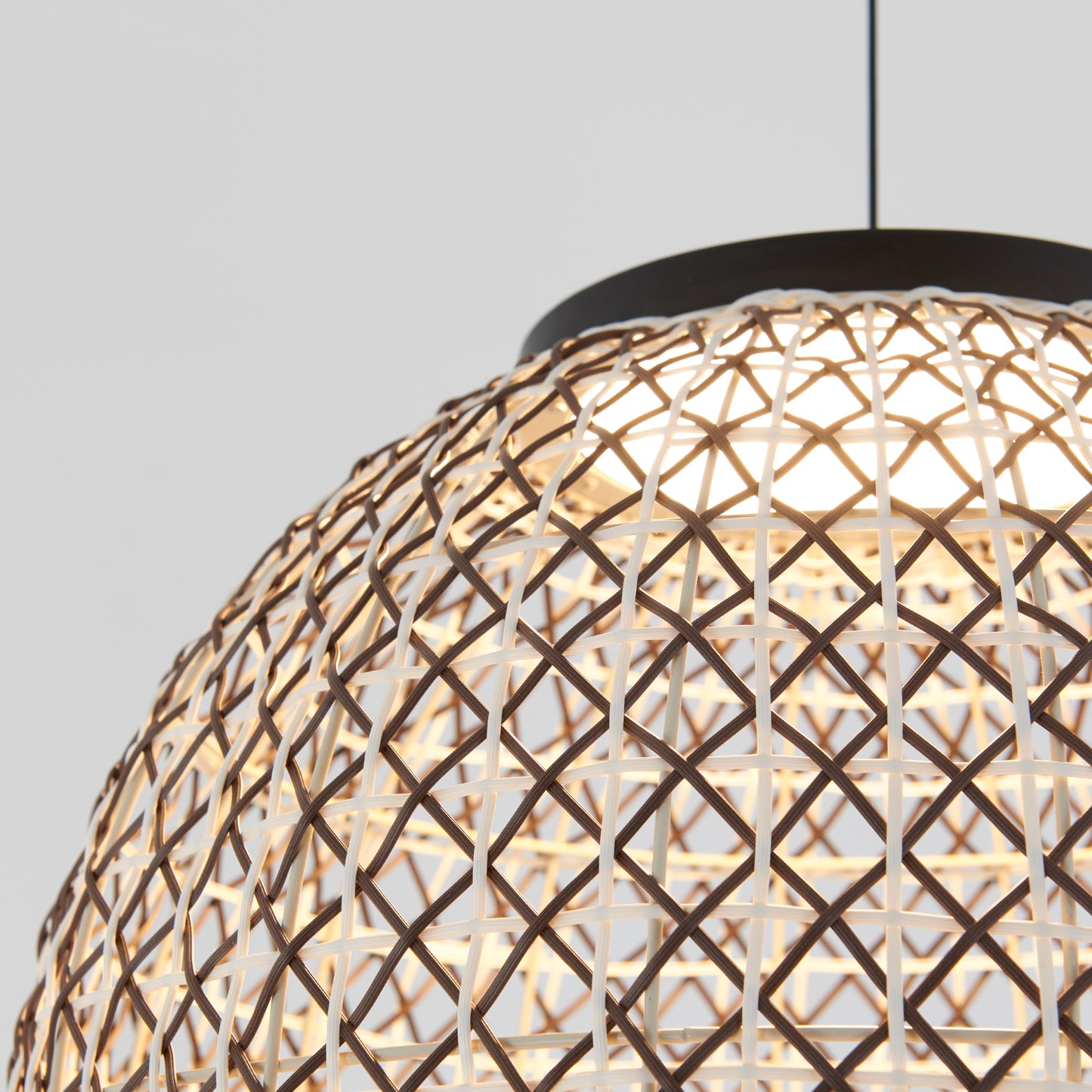 Close-up of the Artika Benson LED pendant light 5 CCT, featuring a geometric woven rattan design and warm illumination, set against a plain light gray background.