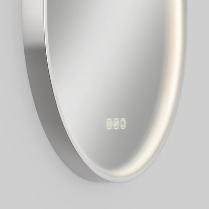 Close-up of the Artika Royce LED mirror 3 CCT with defogger, a modern round design featuring a metal frame, soft built-in LED light ring, and digital clock display on the lower right side.