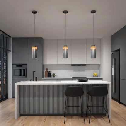 Modern kitchen with gray cabinets, white countertops, a central island with two black barstools, Artikas Hanson 1-light LED pendant 5 CCT above, wood flooring, built-in appliances, plus lemons and wooden utensils for decor.