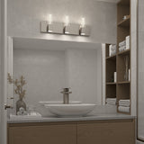 Modern bathroom with a large mirror, vessel sink, sleek faucet, and wooden shelves holding folded towels and decor. Three contemporary lights are mounted above the mirror, and a vase with dried branches sits by the sink.