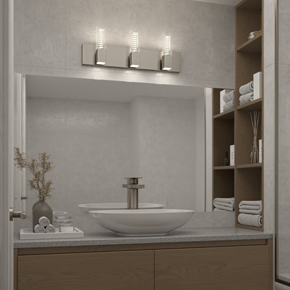 A modern bathroom features a large mirror, rectangular sink, brushed metal faucet, wooden shelves with towels and vases of dried flowers, and the Artika Hologram LED modern bathroom vanity light 5 CCT mounted above the mirror.