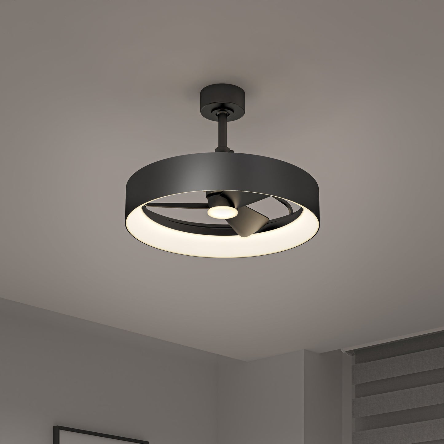 The Artika-CAN-dev Austin 23 in. LED modern ceiling fan features a circular black frame, integrated light, and enclosed blades. Mounted on a gray ceiling, it suits minimalist rooms with neutral walls and window blinds. Includes remote control.