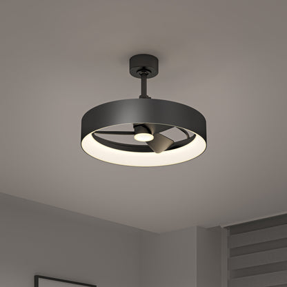 The Artika-CAN-dev Austin 23 in. LED modern ceiling fan features a circular black frame, integrated light, and enclosed blades. Mounted on a gray ceiling, it suits minimalist rooms with neutral walls and window blinds. Includes remote control.