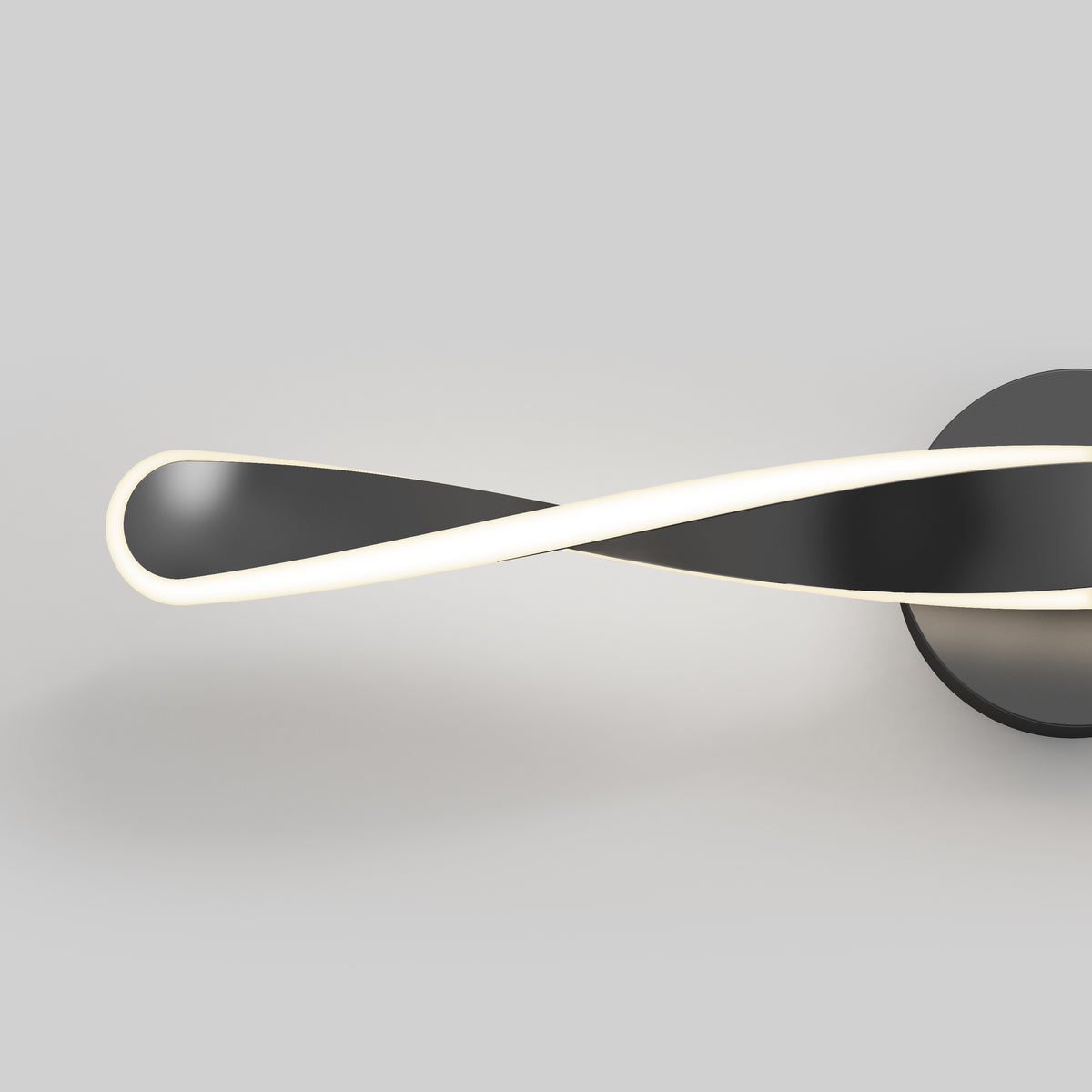 Minimalist wall light fixture with a black, twisted ribbon design and a glowing white edge, mounted on a round base against a plain gray background.