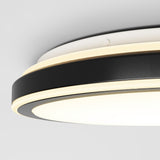 Close-up of a modern, circular ceiling light fixture with a black and white design and built-in LED lighting, mounted on a white ceiling.