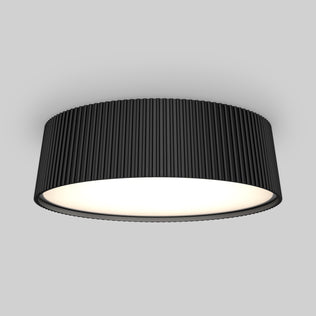 The Artika Groove 13 in. LED modern flush mount light features a black ribbed outer casing and a glowing white diffuser, set against a plain light gray background. Adjustable with 5 CCT settings for versatile lighting.