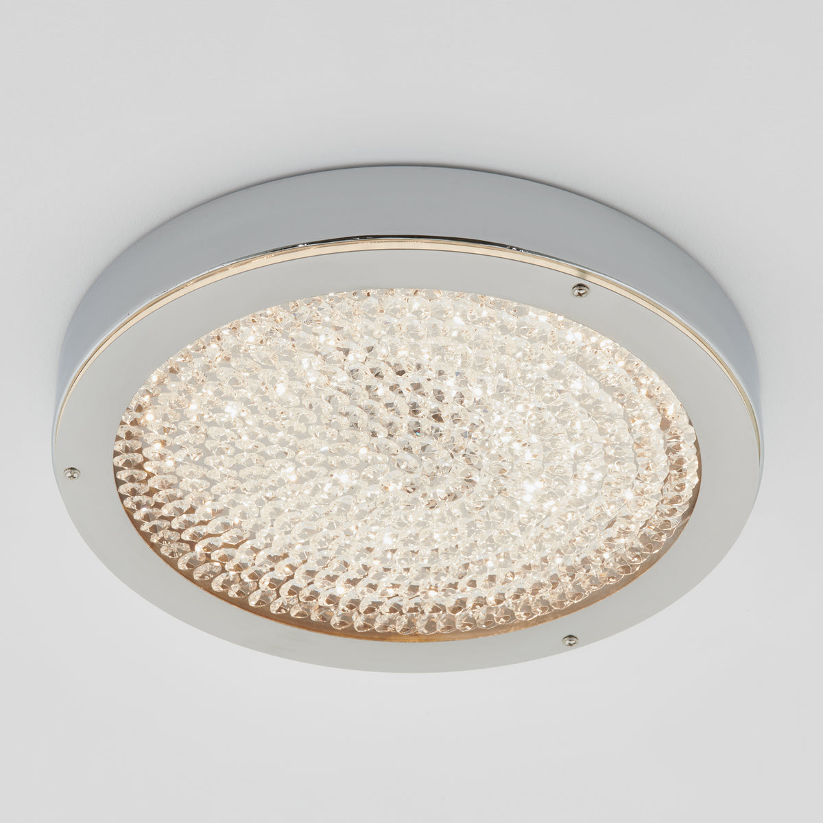 The Artika Glitter LED flush mount features a chrome rim and crystal-like finish, providing bright, energy-saving white light.