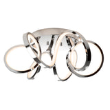 A modern ceiling light fixture with several intertwined, chrome-finished rings that emit a soft white glow, creating an artistic, sculptural appearance.