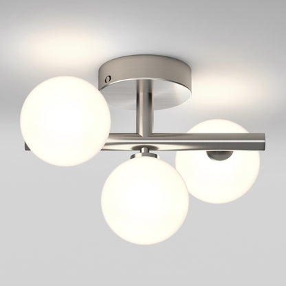 The Artika Bloom LED flush mount features three frosted glass globes on a brushed metal base, mounted to the ceiling and providing soft, even illumination.