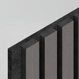 A minimalistic image showing five dark, vertical rectangular pillars casting shadows on a light background. The pillars appear to be made of textured material and are arranged in a row, viewed from an angle.