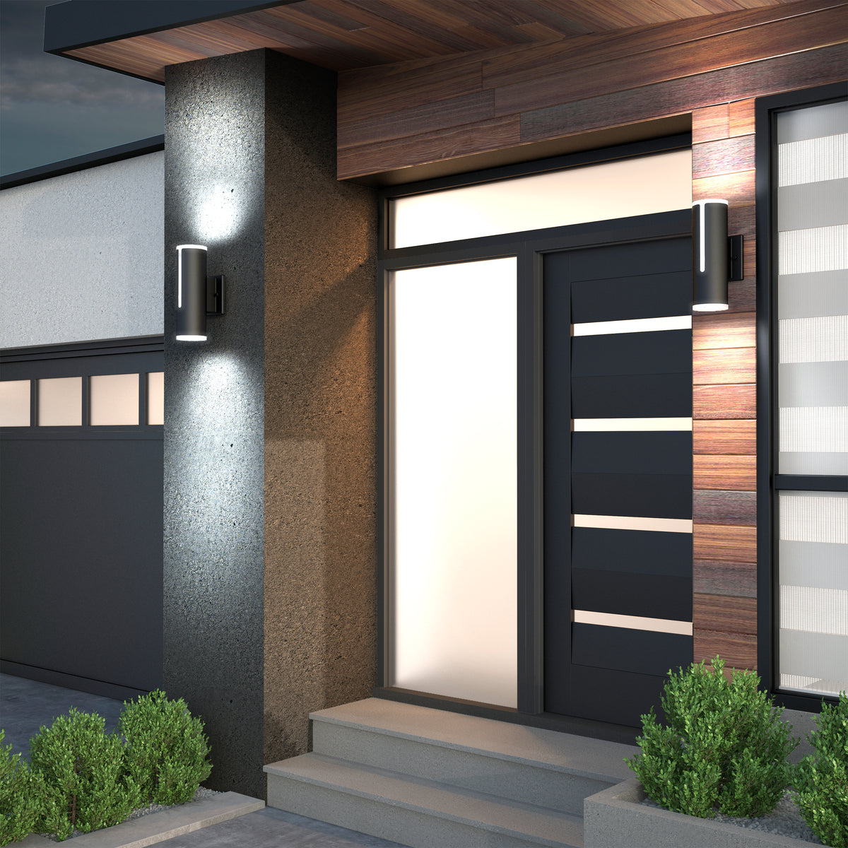 Modern house entrance with a dark door featuring horizontal glass panels, flanked by wall lights. The exterior has wood and concrete textures, steps leading to the door, and small bushes on either side.