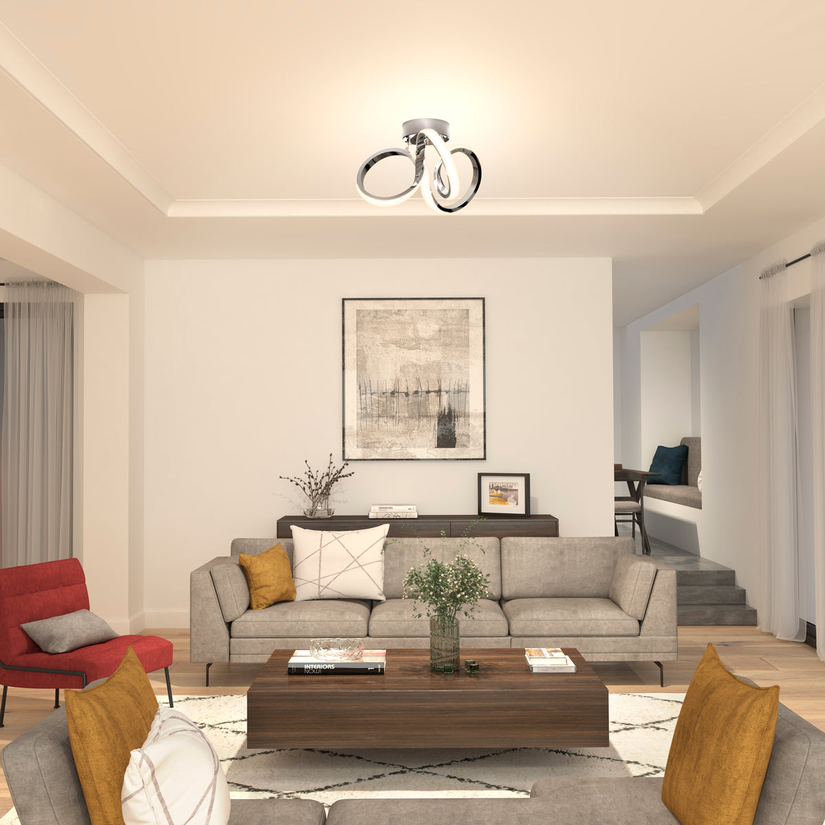 Modern living room with a gray sofa, red and yellow accent chairs, wooden coffee table, large framed artwork, contemporary ceiling light, and neutral decor. Light streams in from windows with sheer curtains.