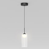 A modern pendant light with a black ceiling mount and cord, featuring a cylindrical clear glass shade and a glowing white bulb inside, hanging against a plain light gray background.