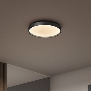 The Artika Celestia 15 in. modern LED flush mount light with remote features a black rim and emits a warm glow, stylishly illuminating modern interiors with smooth surfaces and neutral colors.