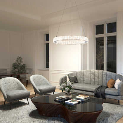 A modern living room with two gray armchairs, a matching sofa, a dark wood coffee table, shag rug, and the Celebrity LED pendant light by Artika. Plants and books rest on the table as natural light pours through tall windows.