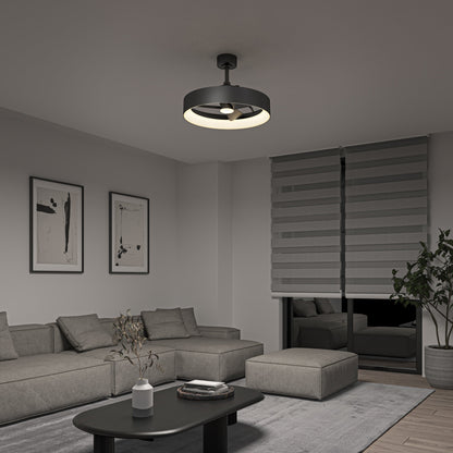 A modern living room featuring a gray sectional sofa, low black coffee table, abstract wall art, large window with layered blinds, a potted plant, and the Artika-CAN-dev Austin 23 in. LED modern ceiling fan with remote lighting the space.