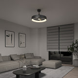 A modern living room with a gray sectional sofa, a black coffee table, abstract wall art, a large plant, and a round ceiling light. The window has striped gray blinds and the room is decorated in neutral tones.