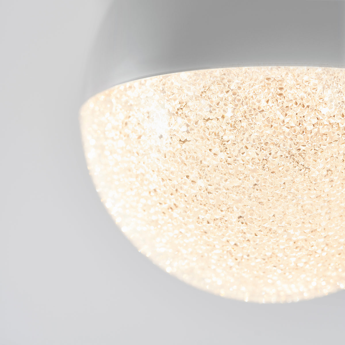Close-up of the Artika Sparkle 1 light LED pendant with a textured, translucent diffuser glowing warmly against a plain white background.