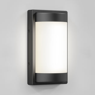 The Artika Fogo modern LED indoor-outdoor wall light 5 CCT features a black metal frame and frosted white glass, shown mounted on a light gray wall.