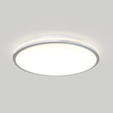 A modern, round, flush-mounted ceiling light with a white diffuser and a slim metallic rim, emitting a soft, even glow against a plain light gray ceiling.