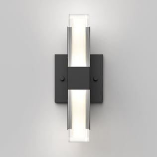 The Artika Gemini indoor-outdoor LED wall light features a rectangular black base and two horizontal frosted glass diffusers, creating a soft white glow on a light gray wall.