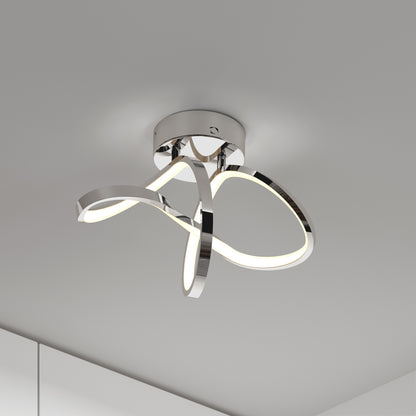 The Artika Loop modern LED flush mount light 3 CCT features polished chrome loops and integrated LEDs, mounted on a white ceiling to enhance a minimalist room corner.