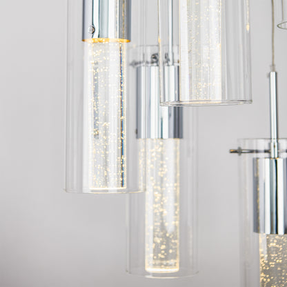 Close-up of the Artika Essence 5-light LED pendant, featuring modern cylindrical glass tubes with chrome finishes and illuminated bubbles inside, set against a neutral background.