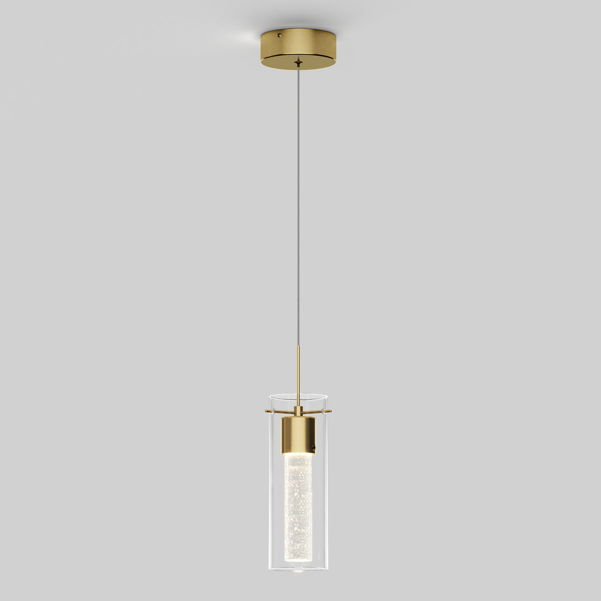 A modern pendant light with a gold ceiling mount, a thin black cord, and a cylindrical glass shade enclosing a textured inner tube, suspended against a plain light gray background.