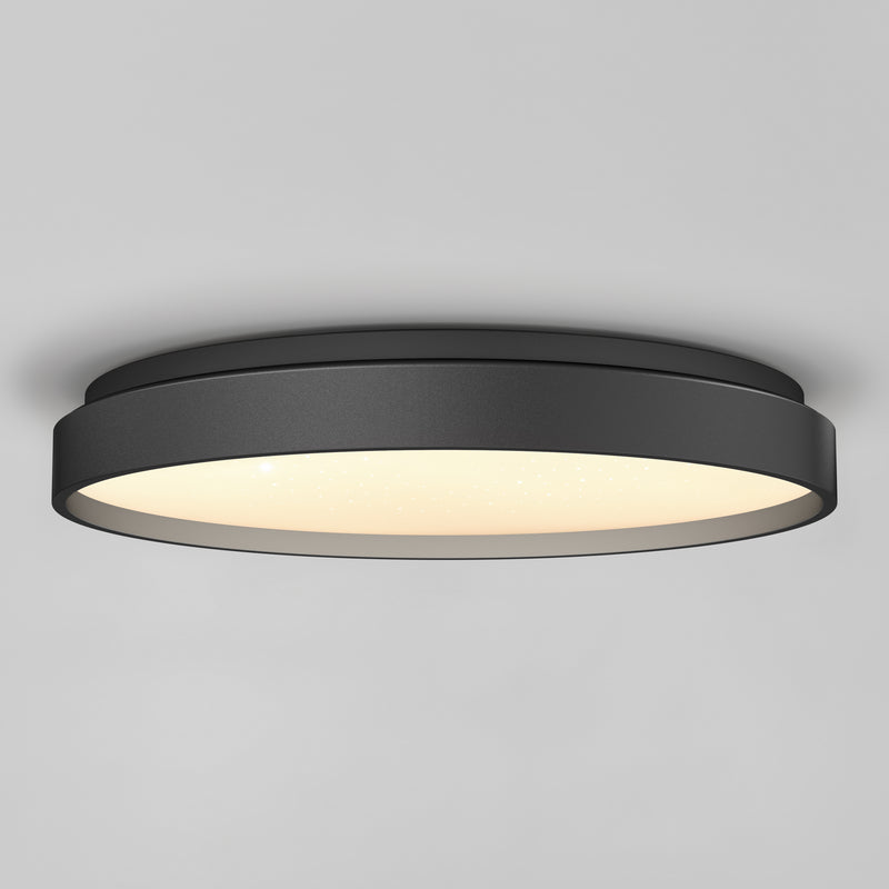 The Artika Celestia 15 in. modern LED flush mount light with remote is installed on a smooth gray ceiling, offering a stylish black finish and soft glowing illumination.