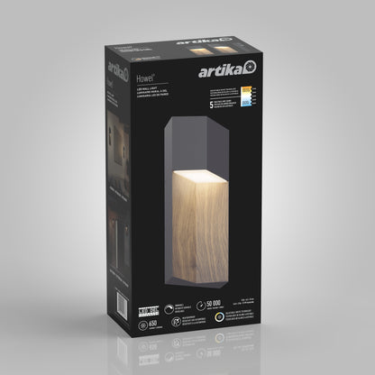 A black Artika box for the Howel modern LED indoor-outdoor wall light 5 CCT shows a glowing wood-textured rectangular fixture on the front, along with its brightness, energy savings, and lifespan details.