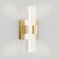 The Artika Dorado contemporary LED wall sconce 3 CCT features a brushed gold rectangular base and four vertical glass rods, emitting adjustable light for a modern, luxurious look on any plain white wall.