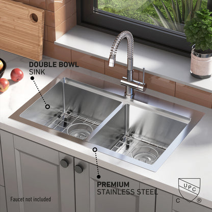 The Artika Newport double bowl stainless steel sink features two spacious bowls and a tall, flexible faucet. Labels showcase its premium stainless steel construction. Apples and a plant sit on the countertop near a window.