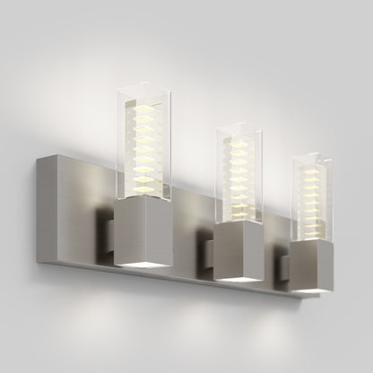 The Artika Hologram LED modern bathroom vanity light 5 CCT features three rectangular lights with clear covers and metallic bases, wall-mounted against a plain light-gray background.