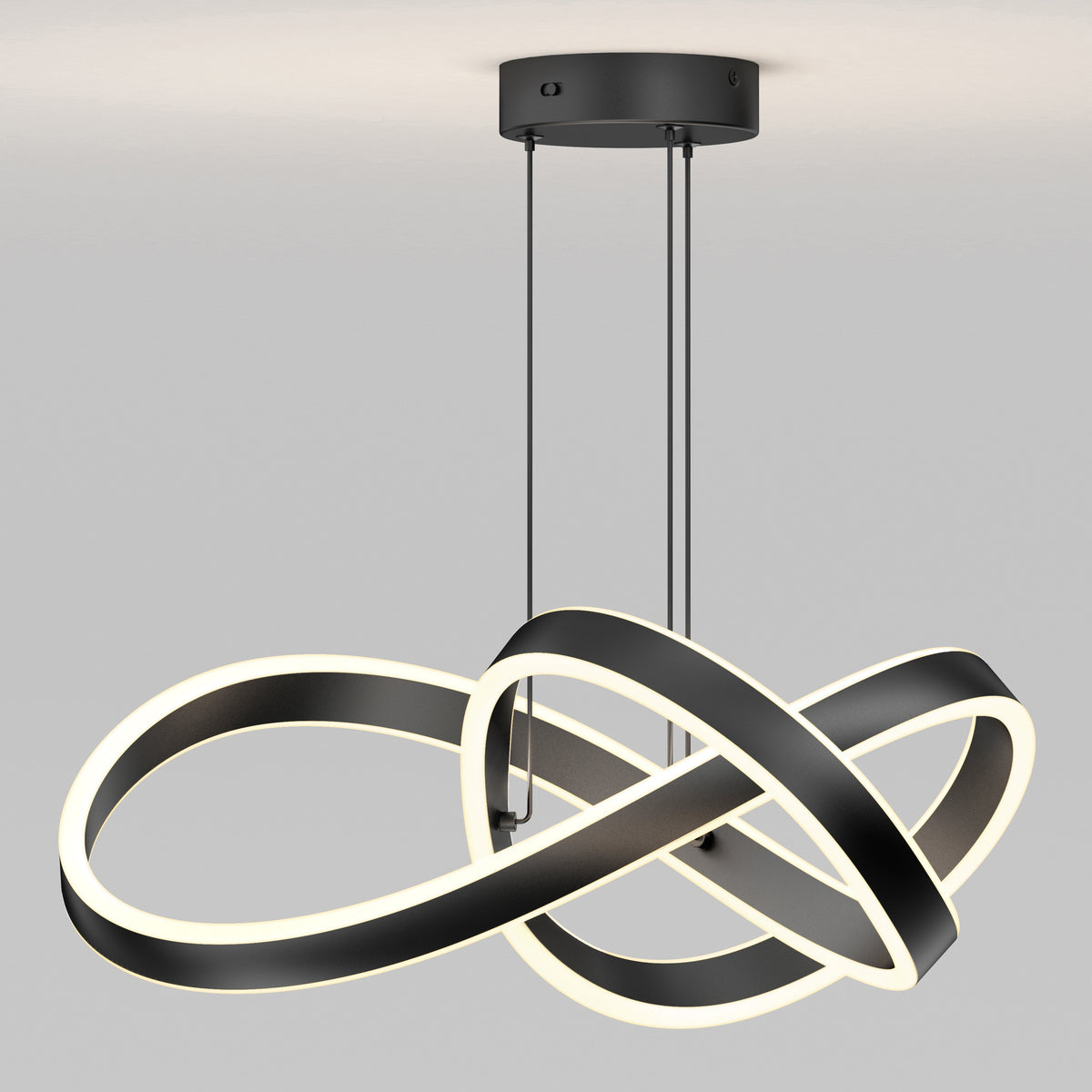 The Artika Bolero LED pendant light 5 CCT features two interlocking black and white loops suspended from the ceiling, providing a soft, even glow against a plain light gray background.