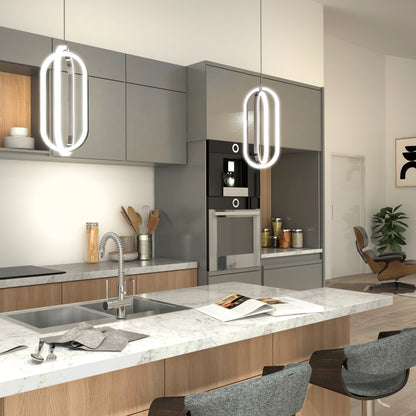 Modern kitchen features marble countertops, gray and wood cabinetry, built-in oven, and two Artika Arlo 1-light LED pendants. Open shelves hold jars; the island has a sink and stools, with a lounge chair and plant in the background.