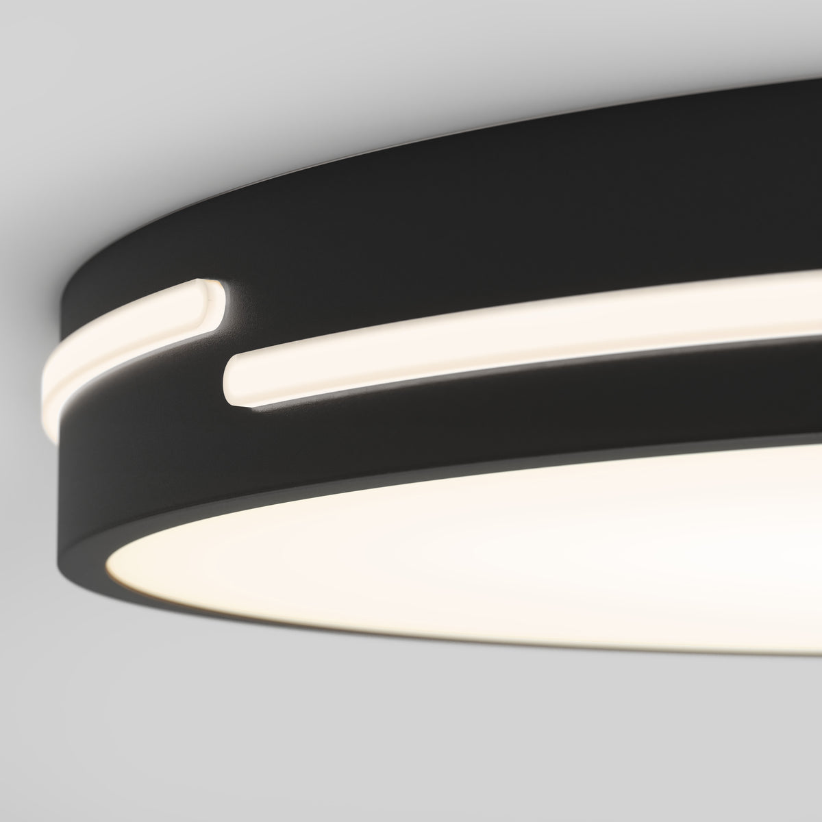 A close-up of the Artika Delray 15.7 in. LED modern flush mount light, featuring a circular black design with a glowing white ring and horizontal slit, showcases its minimalistic style against a light gray background. 5 selectable CCT settings included.