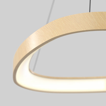 Close-up of Artika’s Bjorn modern LED pendant light 5 CCT, featuring a curved light wood design with an inner LED strip, suspended by two thin black wires against a plain gray background.