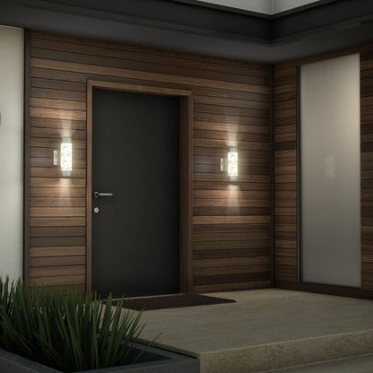 A modern house entrance features a dark door, wood paneling, Artika Bubble Element LED indoor-outdoor lights on either side, a welcome mat, frosted glass window, and a small planter with green plants.