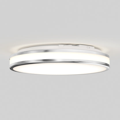 The Artika Hemisphere 15 in. LED flush mount light features a modern round design with a metallic rim, adjustable brightness (5 CCT), and a white illuminated surface, mounted on a plain light-colored ceiling.
