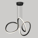 Modern black pendant light fixture with three intertwined, curved LED loops hanging from a round ceiling mount against a plain gray background. The loops emit a soft white glow.
