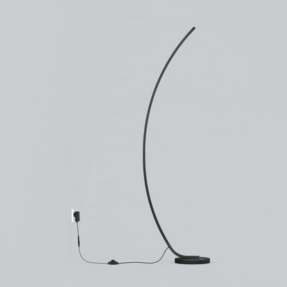 The Artika Arc LED Floor Lamp features a minimalist, modern design with a thin curved black stem on a round base. It plugs into a wall outlet with a visible black cord and foot switch, all set against a light gray background.