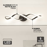Modern wall light fixture with a wavy, black aluminum frame and LED strip, marked “Aluminum with matte black finish” and “Rubber diffuser, no bulbs required.” Icons show “Integrated LED” and “5 years warranty.”.