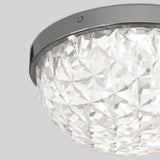 Close-up of a decorative ceiling light fixture with a faceted, clear glass dome and a shiny, metallic frame, mounted on a light gray ceiling.