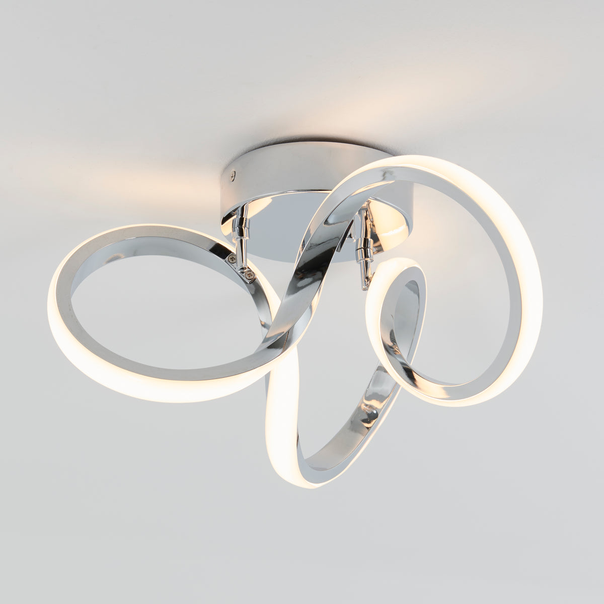 Modern ceiling light fixture with three interlocking chrome loops, each lined with an integrated LED strip, mounted on a round chrome base against a white ceiling.