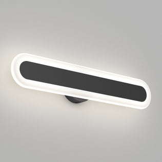 The Artika Pista modern LED bathroom vanity light 5 CCT is a matte black, wall-mounted, oval fixture with a black central panel and glowing white border, offering dimmable lighting for a sleek look on a light gray wall.